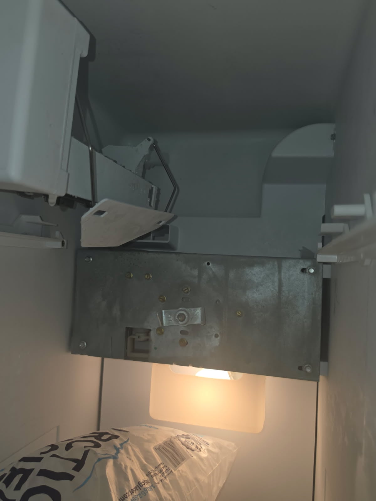 Close-up of the defective ice maker part removed from the refrigerator